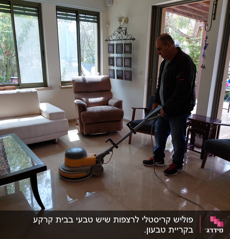 אדם מנקה רצפה עם מכונת פוליש חשמלית בסלון מואר